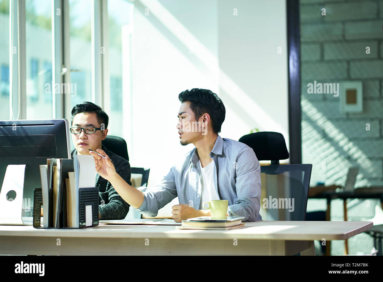 Zwei jungen asiatischen Geschäft Leute zusammen arbeiten im Büro diskutieren. Stockfoto