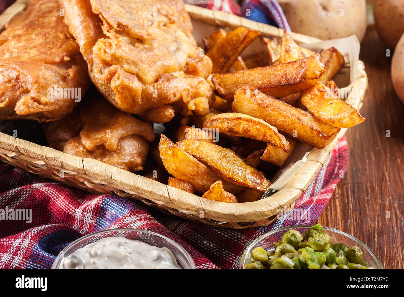 Traditionelle Fisch im Bierteig und Chips auf Korb serviert. Stockfoto
