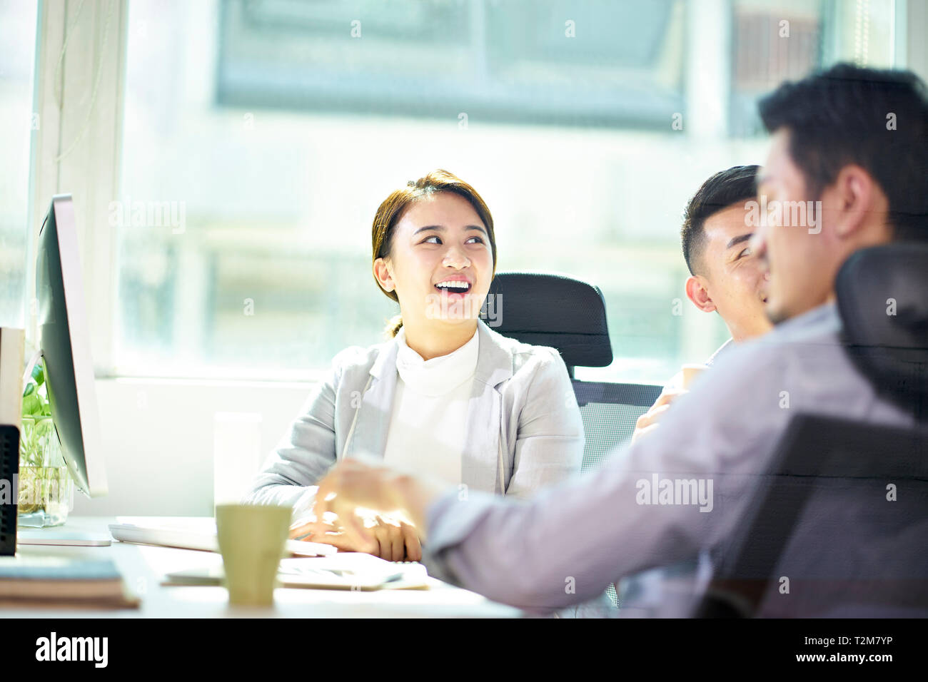 Drei junge asiatische Unternehmer treffen im Büro, glücklich und lächelnd. Stockfoto