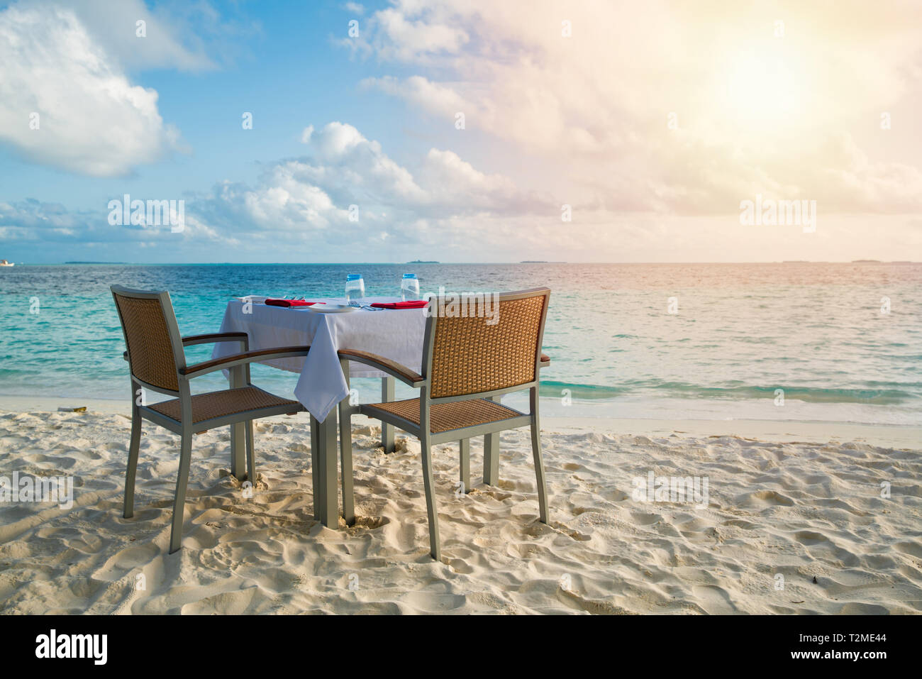 Tisch outdoor neben Meer scenic für romantische Abendessen mit Sonnenlicht vorbereiten Schattierung Stockfoto
