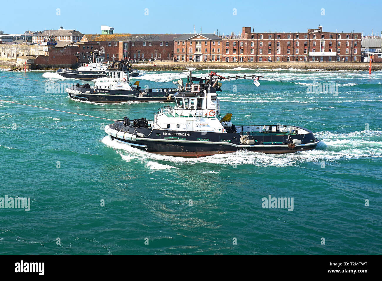 Drei SERCO GMBH, leistungsfähige Schlepper unterstützen die Royal Navy Flugzeugträger HMS QUEEN ELIZABETH als Sie geht Fort Blockhaus, Gosport. Portsmouth Harbour. Stockfoto