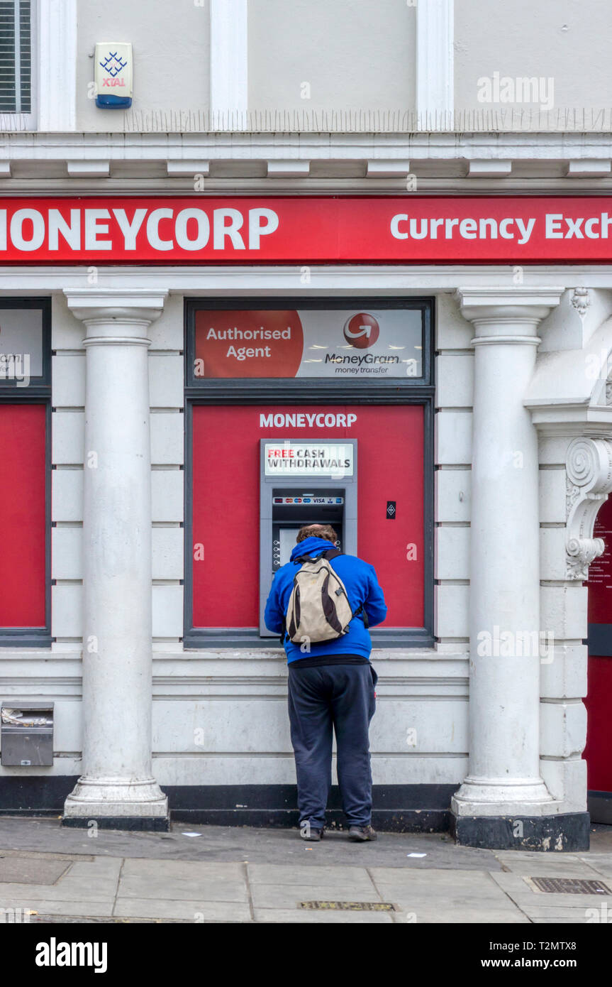 Mann mit MoneyCorp kostenloser Bargeldbezug Maschine. Stockfoto