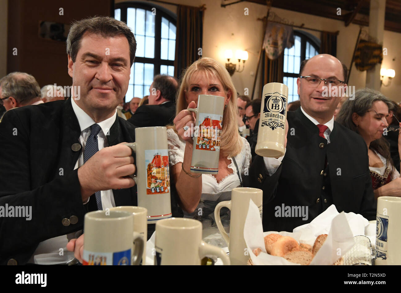 03 April 2019, Bayern, München: Markus Söder (CSU), l-r), Ministerpräsident von Bayern, und seine Frau Karin, sowie Albert Füracker, Bayerischer Staatsminister der Finanzen und Inneres, trinken die Erste an der Maibock Maibock tippen in das Hofbräuhaus. Foto: Felix Hörhager/dpa Stockfoto