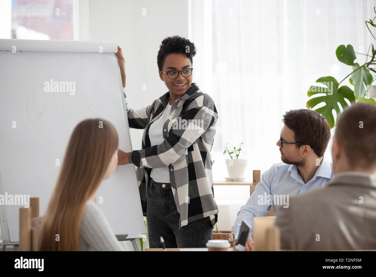 Geschäft Leute an Seminar Konferenz im Büro. Schwarze afrikanische Führer Chef weiblichen Ständigen zeigen, auf der Tafel Entwicklungsstrategie Grafik Stockfoto
