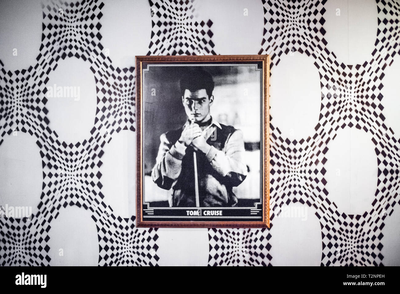 Ein schwarz-weiß Foto eines jungen Tom Cruise, hängt gegen 70s style psychedelische Tapete. Stockfoto
