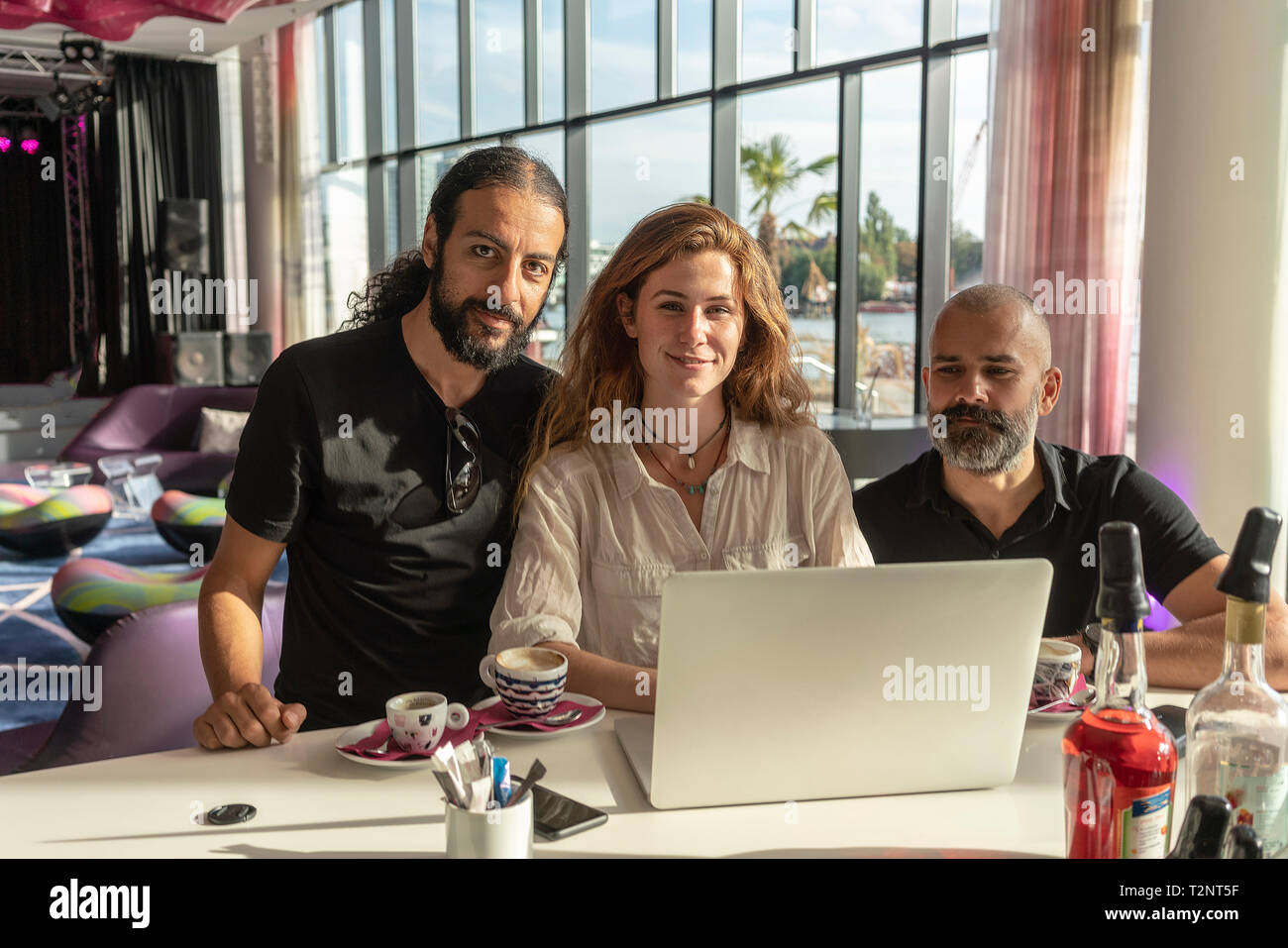 Gruppe von drei Unternehmer mit Laptop und Kaffee im Büro Stockfoto