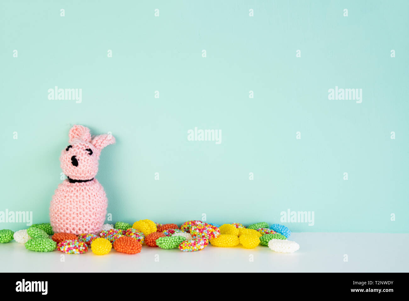 Gefüllte bunny Toy mit farbigen Süßigkeiten vor einem farbigen Hintergrund, mit Platz daneben Stockfoto