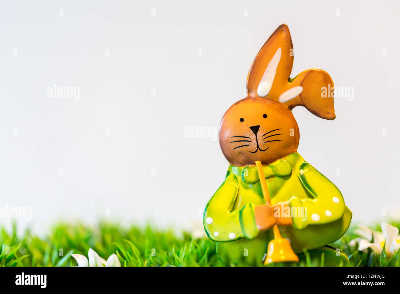 Ein Kleines Kaninchen Statue In Gras Auf Einem Weissen Hintergrund