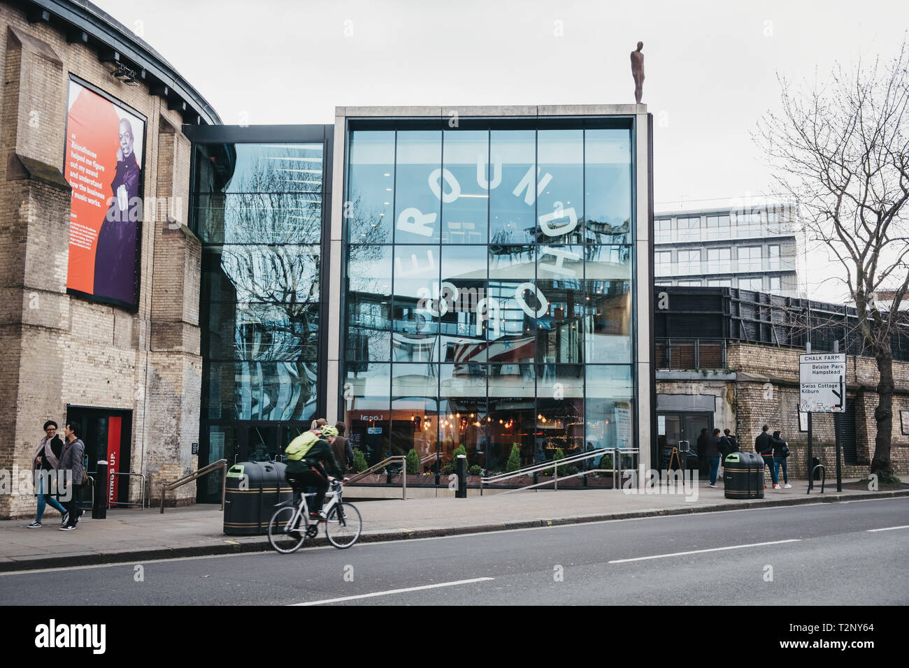 London, UK, 23. März 2019: Radfahrer und Menschen vor der Roundhouse, eine darstellende Kunst und Konzerte an der Güteklasse II aufgeführten ehemaligen Stockfoto