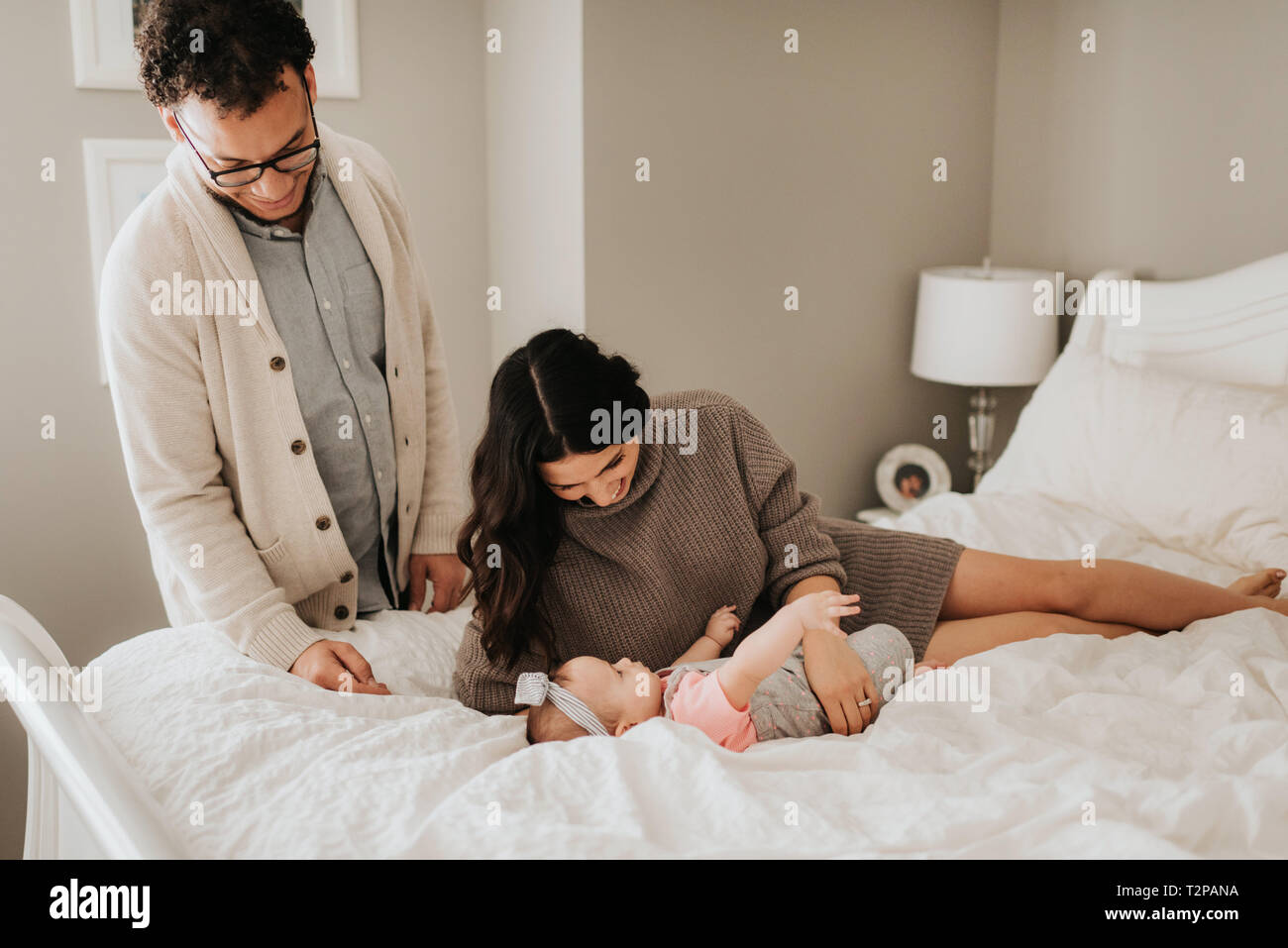 Paar mit Tochter auf dem Bett im Schlafzimmer Stockfoto