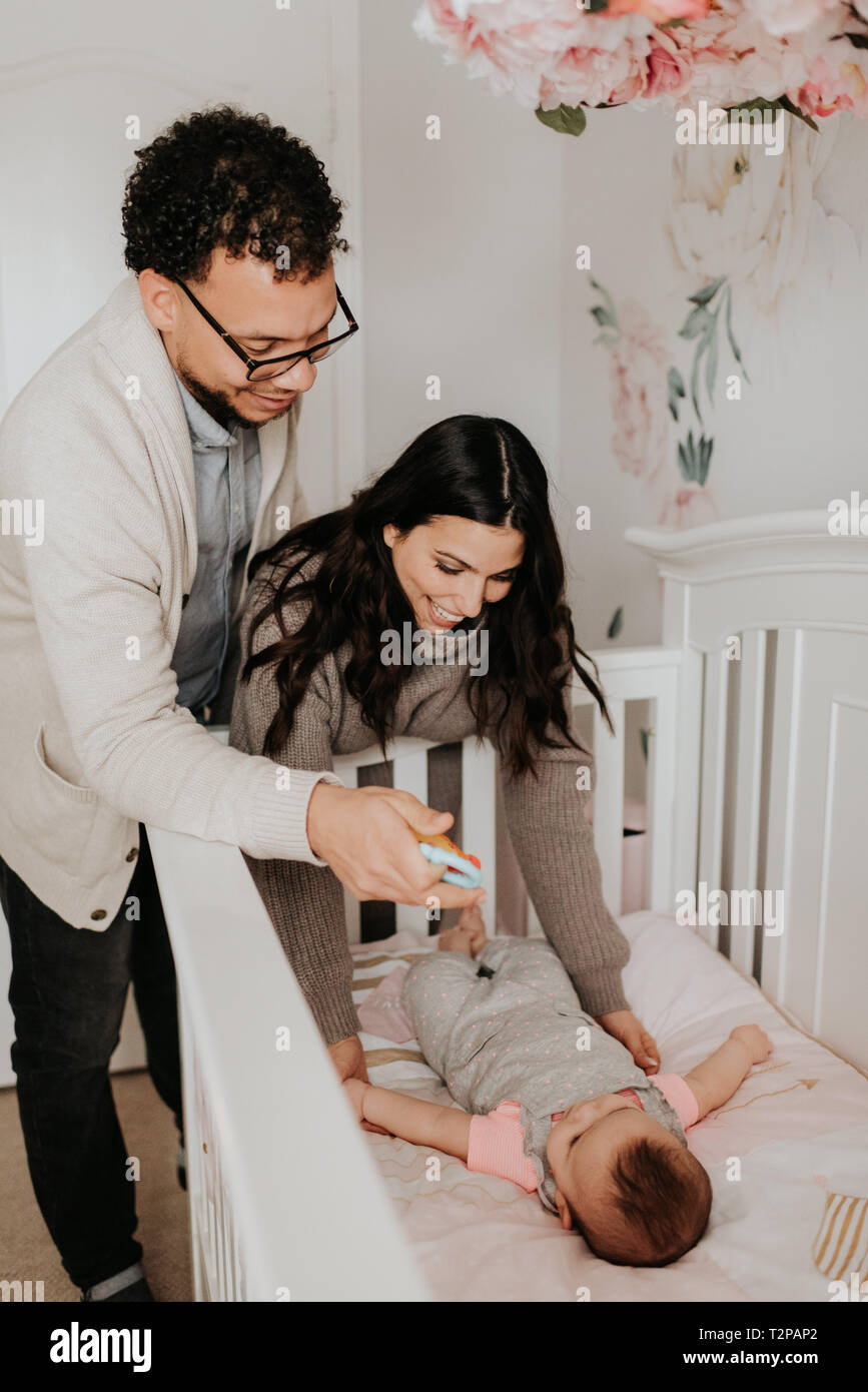 Paar, baby Tochter zu Bett im Kinderbett Stockfoto