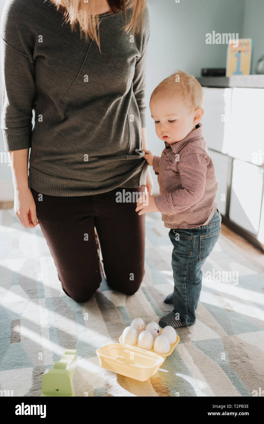 Mutter Knien in Wohnzimmer mit Baby Sohn Stockfoto