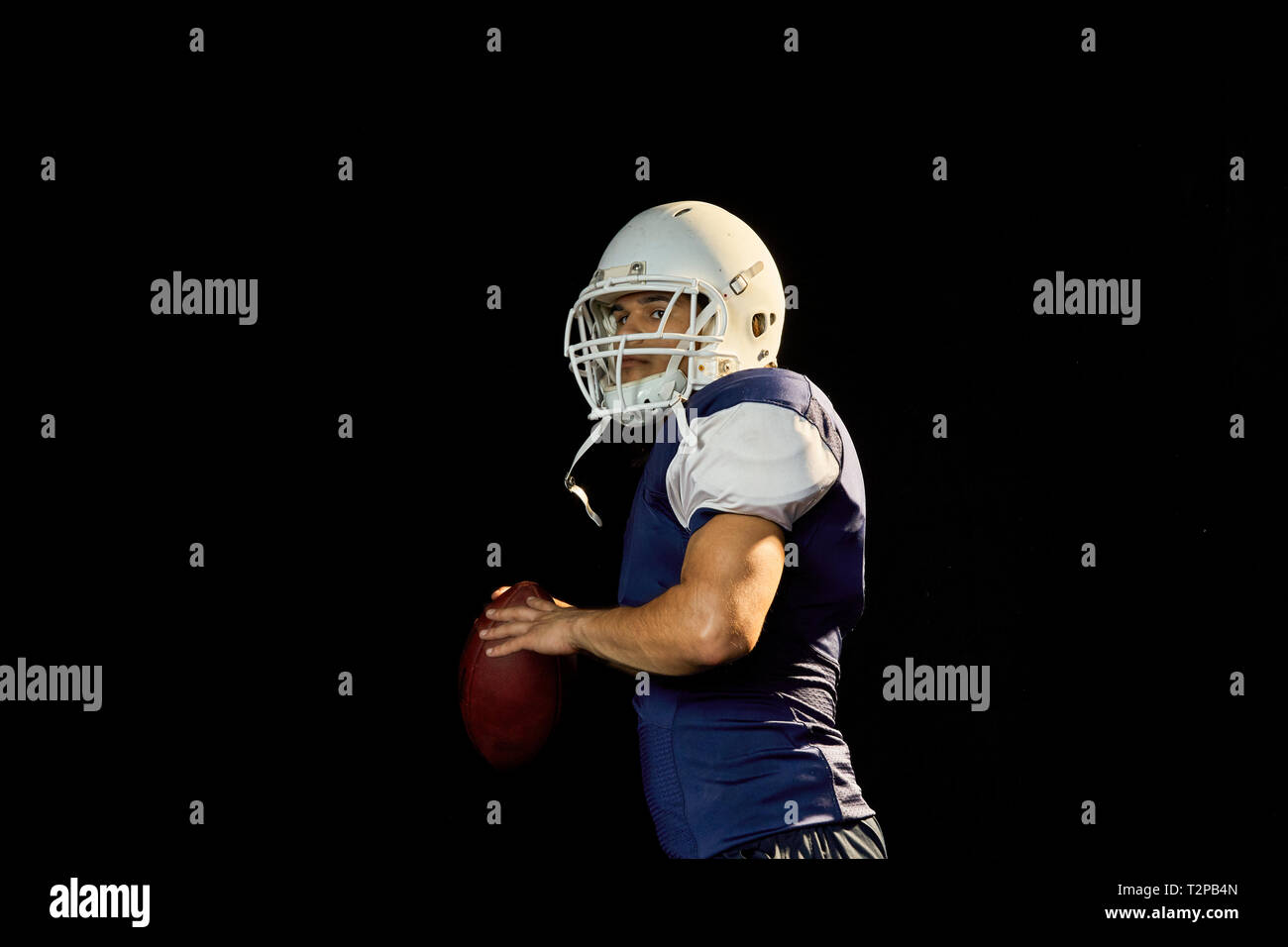 Portrait von Quarterback mit Fußball, schwarzer Hintergrund Stockfoto