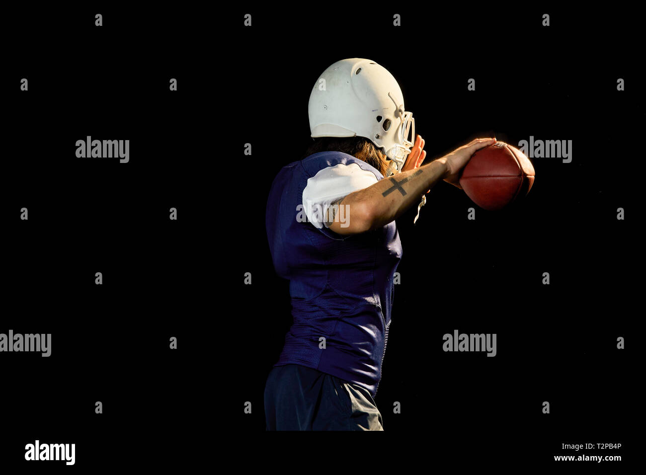 Portrait von Quarterback mit Fußball, schwarzer Hintergrund Stockfoto