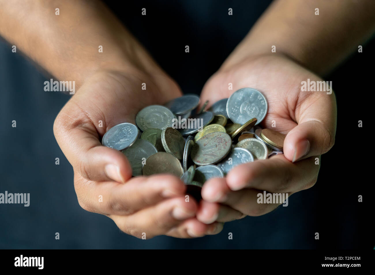 Münzen in den Händen. Geld sparen. Indische Münzen, die für den Hintergrund. Stockfoto