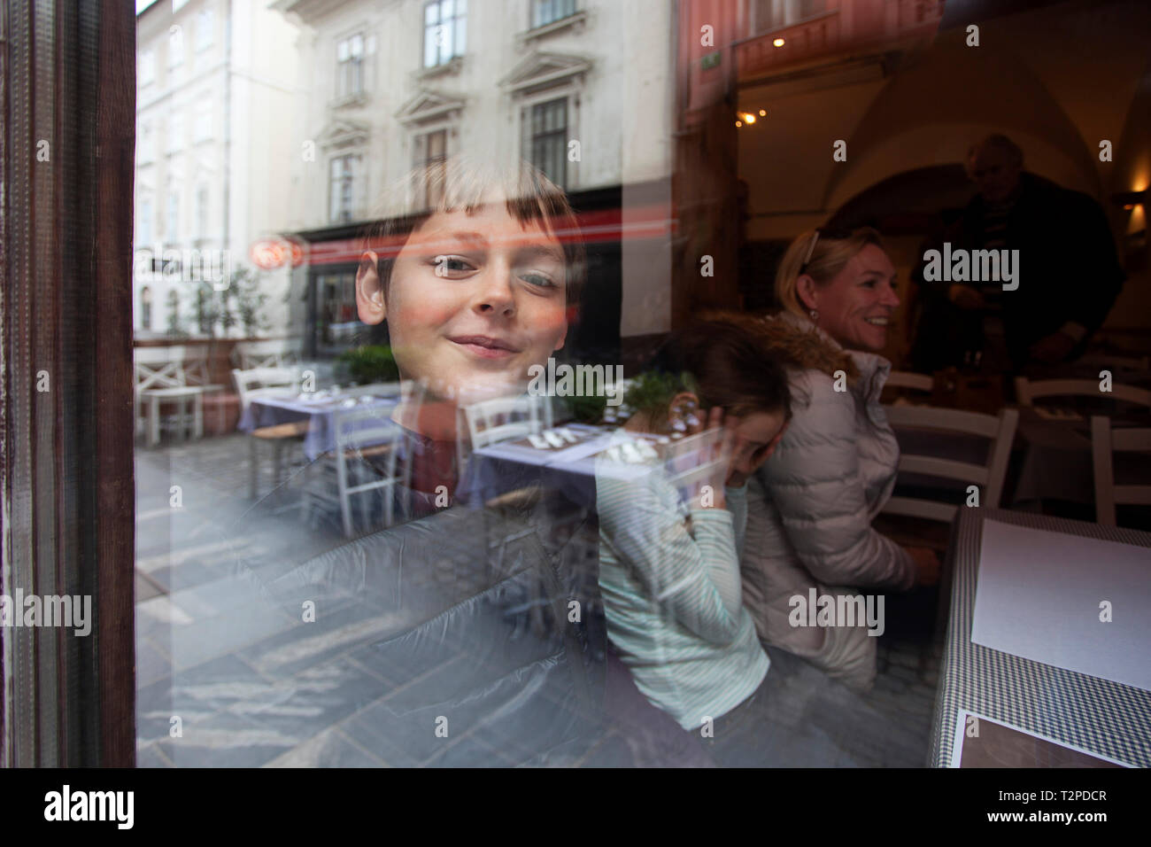 Lächelnde Junge im Restaurant Fenster Stockfoto