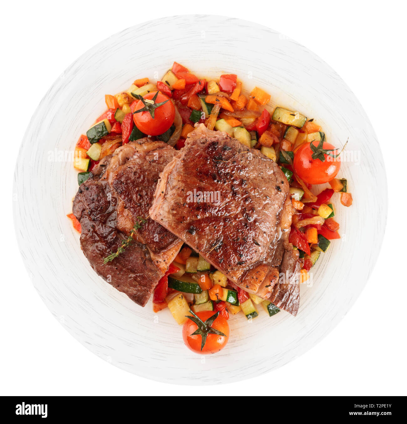 Ribeye Steak mit gebratenem Gemüse auf weißem Hintergrund Stockfoto