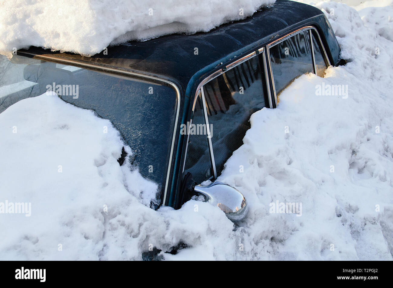Dunkel blaues Auto mit Snow Drift abgedeckt. Im Winter draußen. Stockfoto