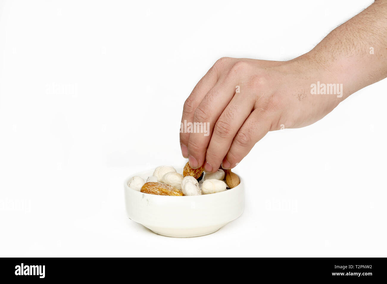 Bild des Menschen Hand ist die Kommissionierung trockene Frucht. Auf den weißen Hintergrund isoliert. Stockfoto