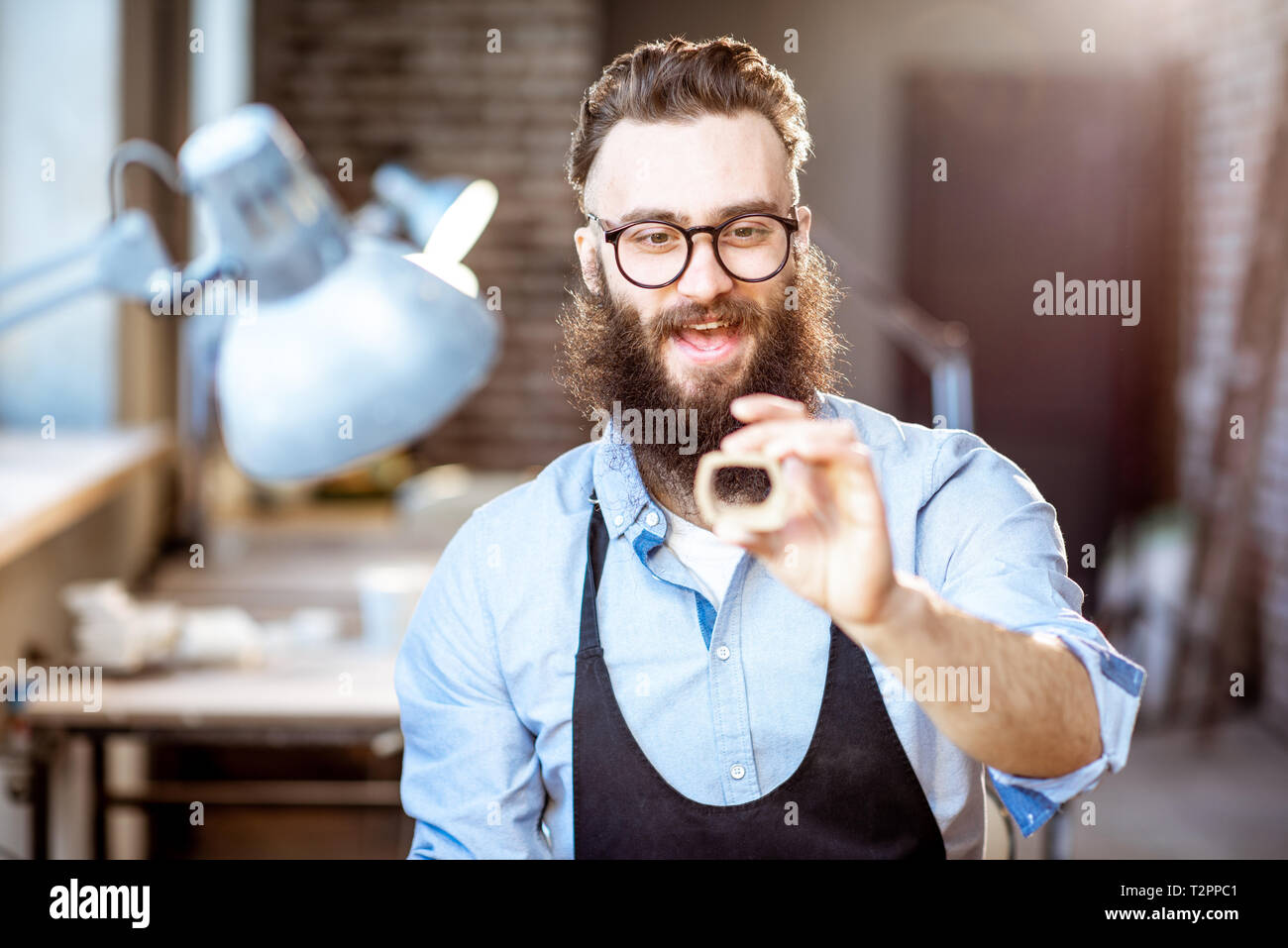 Happy bärtiger Mann arbeiten mit keramischen Werkstücken am Arbeitsplatz der Töpferei shop Stockfoto