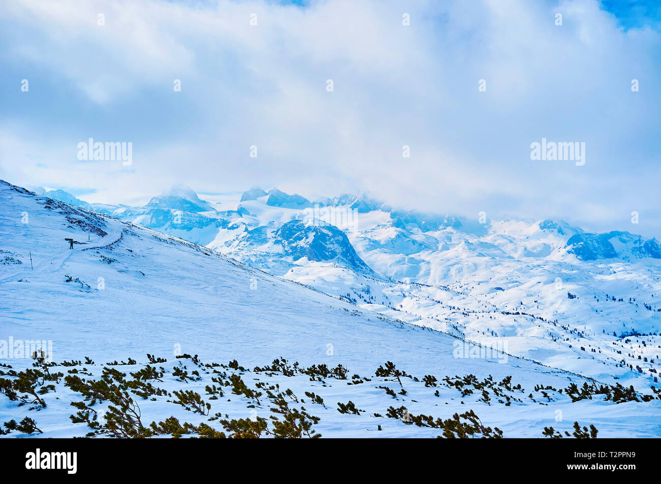 Der Krippenstein Hang öffnet sich der Blick auf den felsigen Gipfeln der Dachsteinmassiv, mit schweren Wolken, Salzkammergut, Österreich abgedeckt. Stockfoto