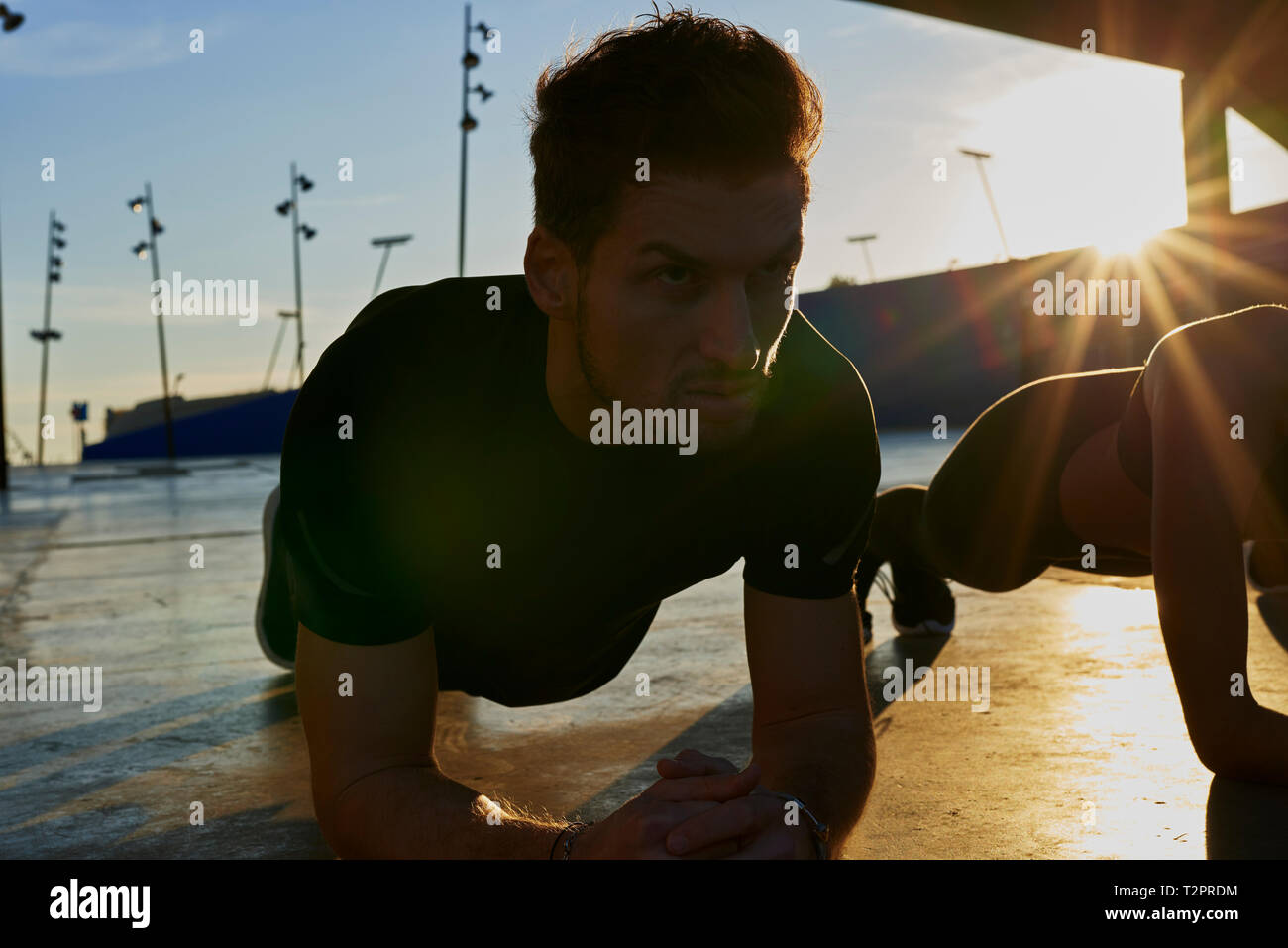 Freunde plank im Stadion bei Sonnenuntergang Stockfoto