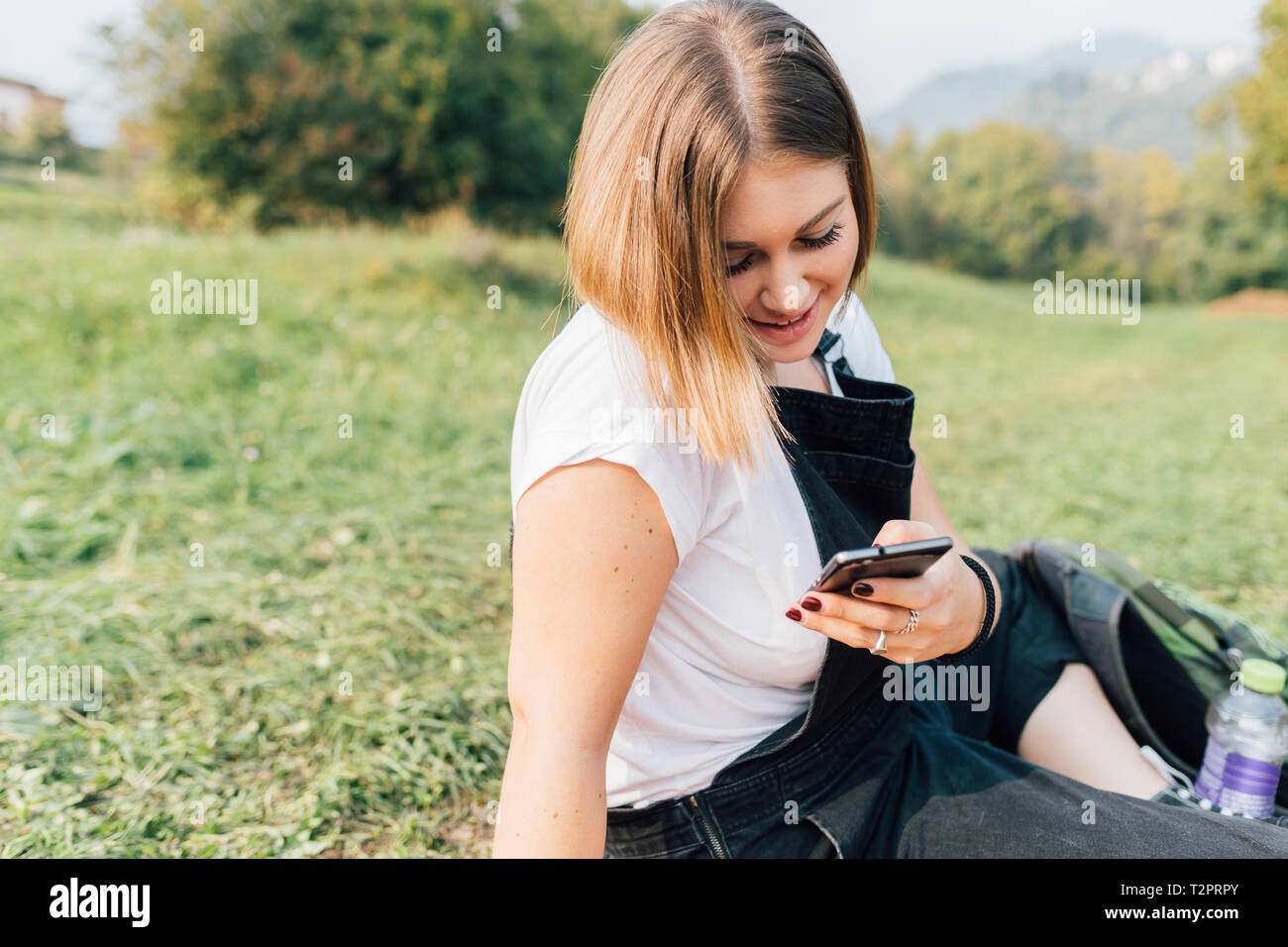Frau Textnachrichten auf Gras Stockfoto