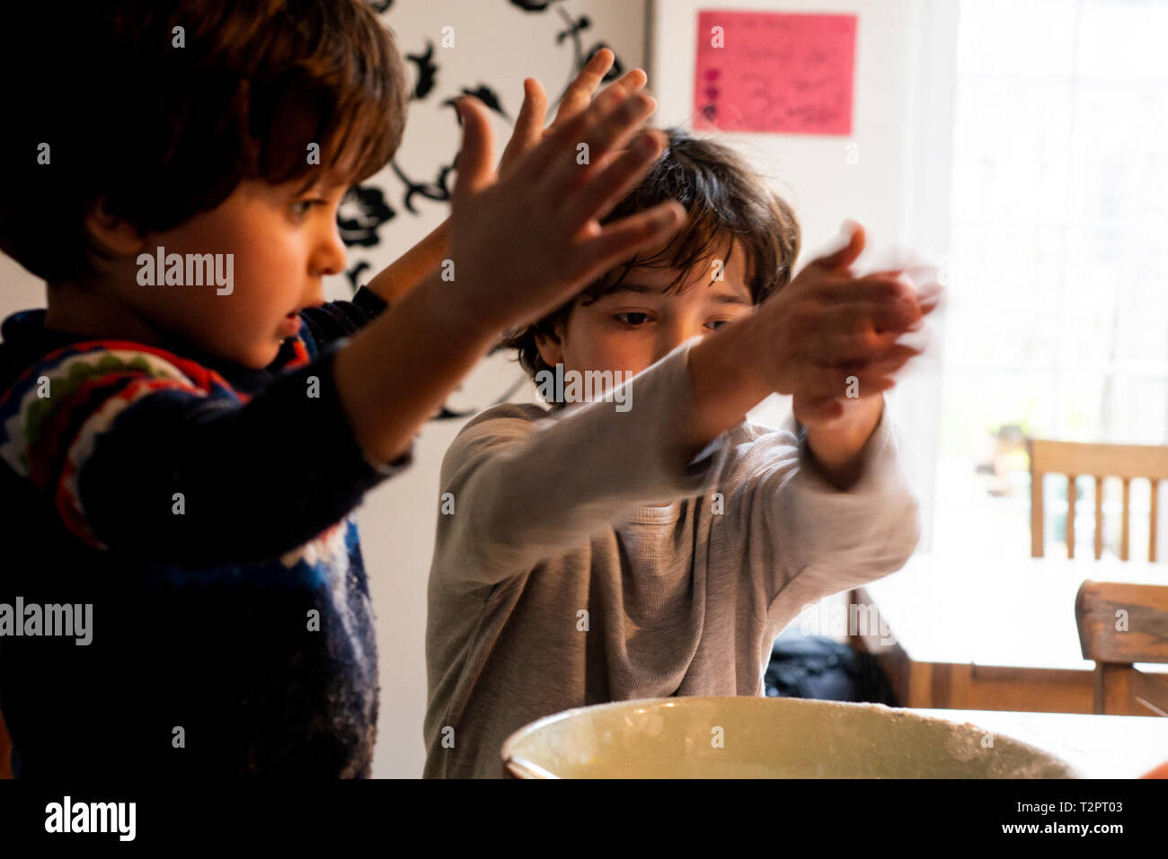 Jungen spielen mit Mehl in Schüssel Stockfoto