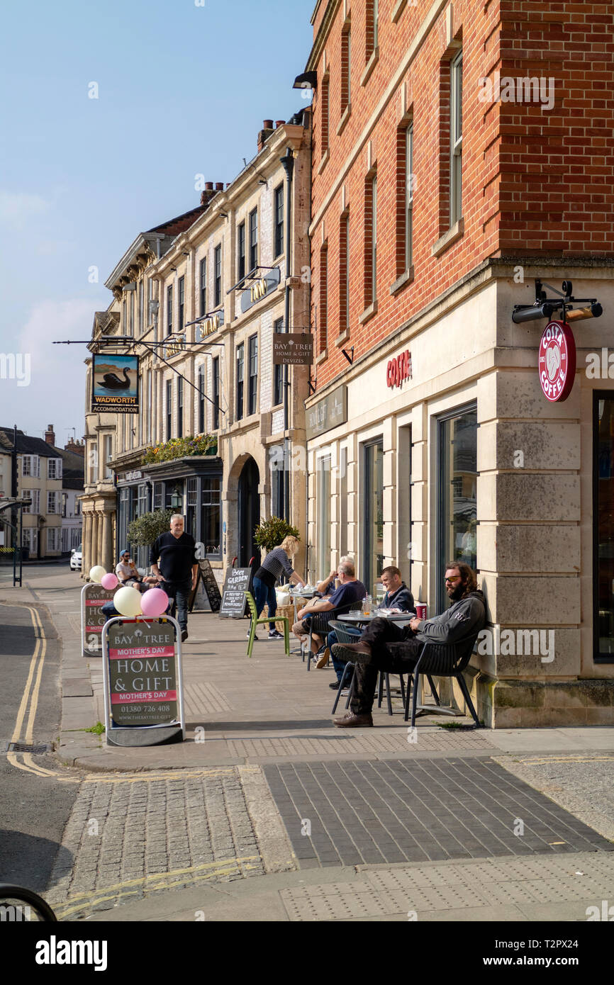 Devizes, Wiltshire, England, UK. März 2019. Kunden außerhalb einen Pub und ein Café auf der Straße sitzt. Stockfoto