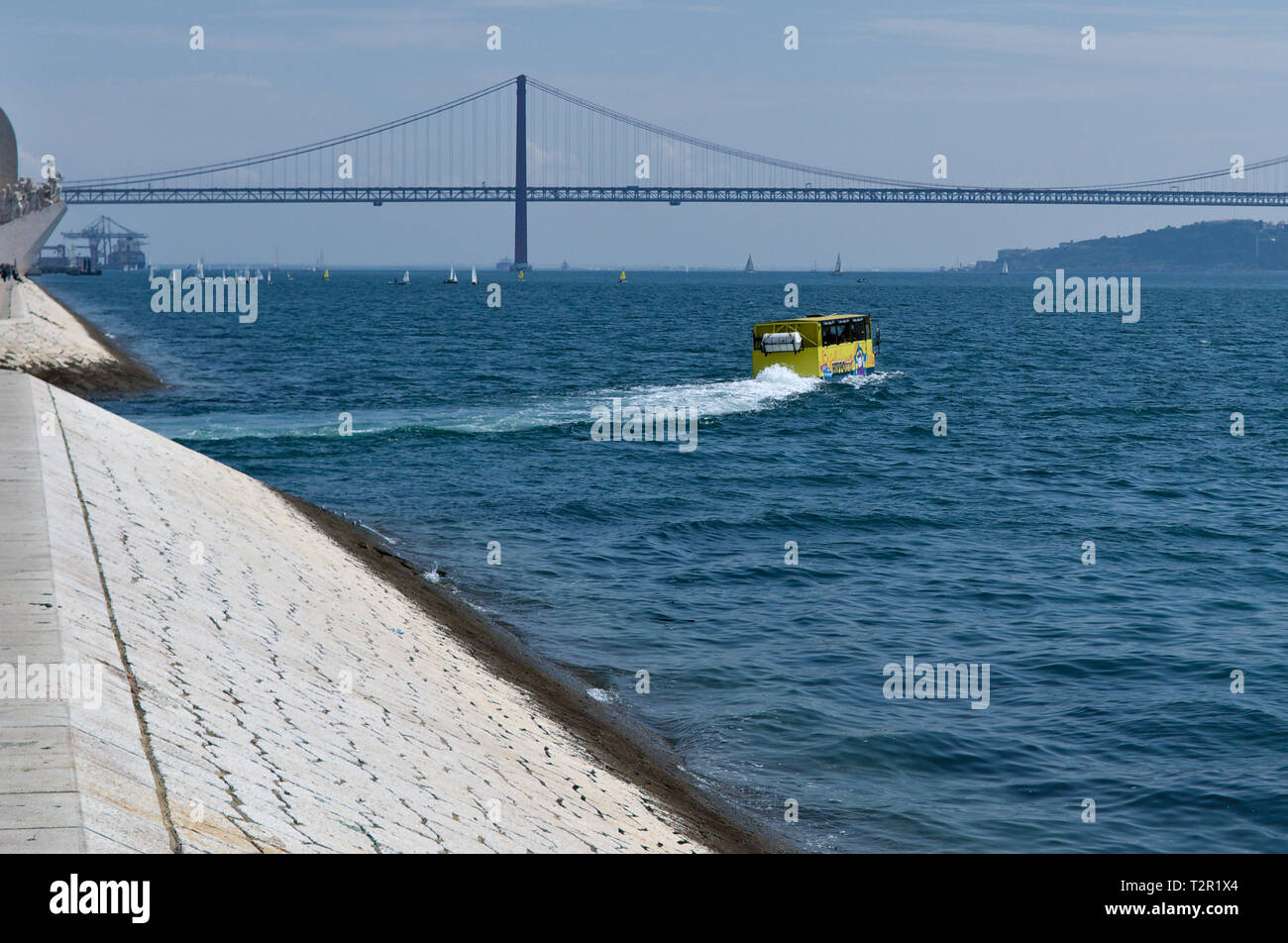 Gelbe amphibienbus unter 25 Abril Brücke, Lissabon, Portugal. Stockfoto