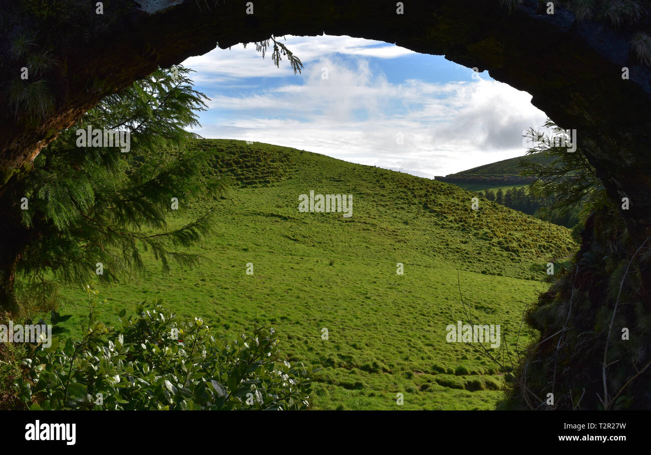 Blick auf ein grünes Feld durch einen Aquädukt Torbogen sichtbar. Stockfoto