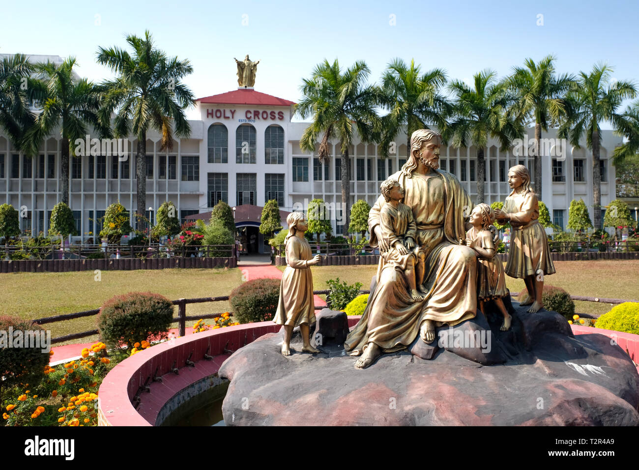 Bronzestatue von Jesus Christus mit Kindern vor der katholischen Heiligen Kreuz Schule in Argatala, Bundesstaat Manipur im Nordosten Indiens. - - - Der katholischen Heiligen Kreuz Schule in Argatala, Bundesstaat Tripura, Nordost-Indien. Stockfoto