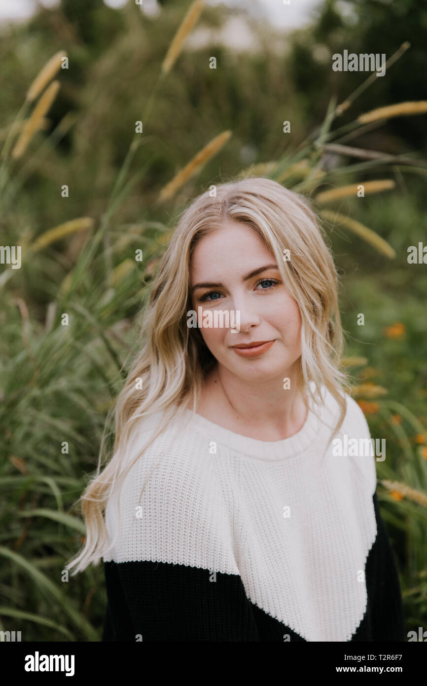 Schöne attraktive blonde Haare junge Messe gehäutet kaukasische Frau mit hübsch Lächeln in der Natur für Headshot Porträts außerhalb Stockfoto