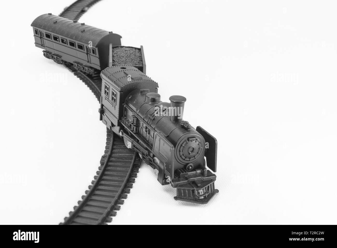 Schwarz lackiertes Spielzeugmodell mit Dampfmaschine. Für abseits der Strecke, finanziellen Crash, vom Kurs abgekommen, Zugunfall, ups, Entgleisung, SVB-Bank-Kollaps-Metapher Stockfoto