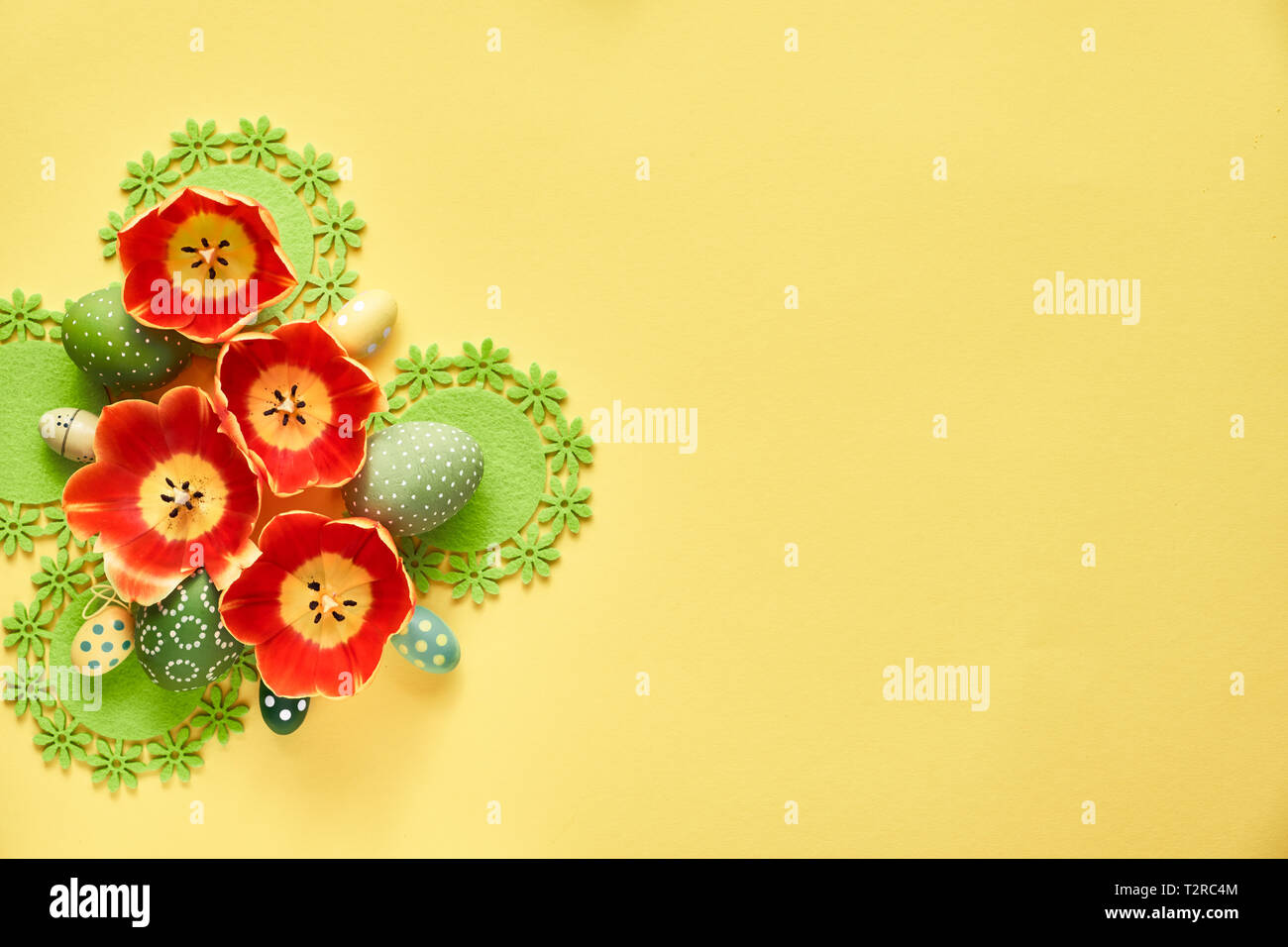 Ostern flach auf gelbem Papier Hintergrund. Anordnung von Tulip Blumen und Ostereier, copy-Platz auf der Seite. Stockfoto