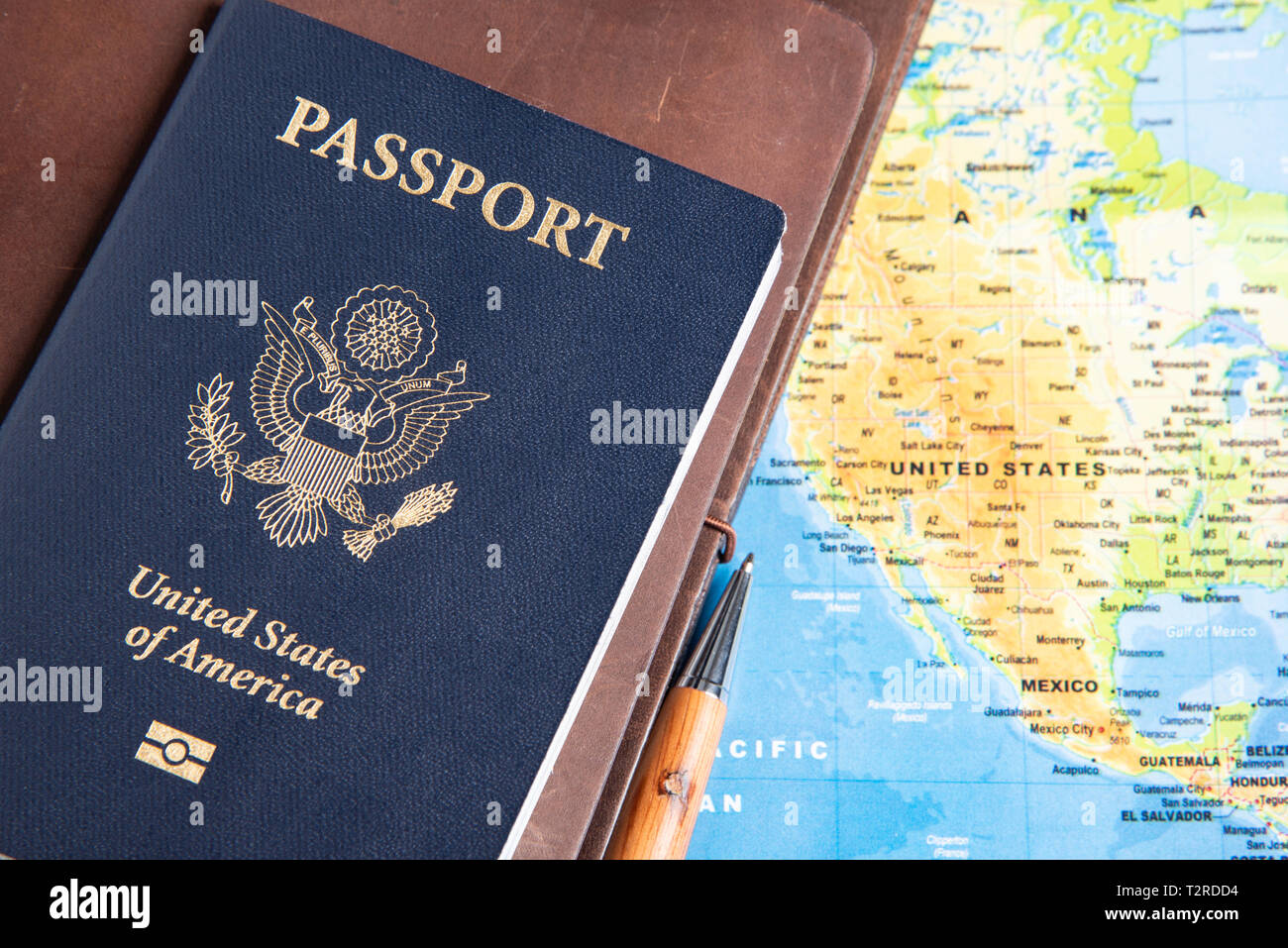 Eine Hochschule der amerikanischen Blaue Abdeckung Reisepass mit einem  gefalteten Weltkarte, leder Zeitschriften, und Stifte auf einem schlichten  weißen Hintergrund Stockfotografie - Alamy