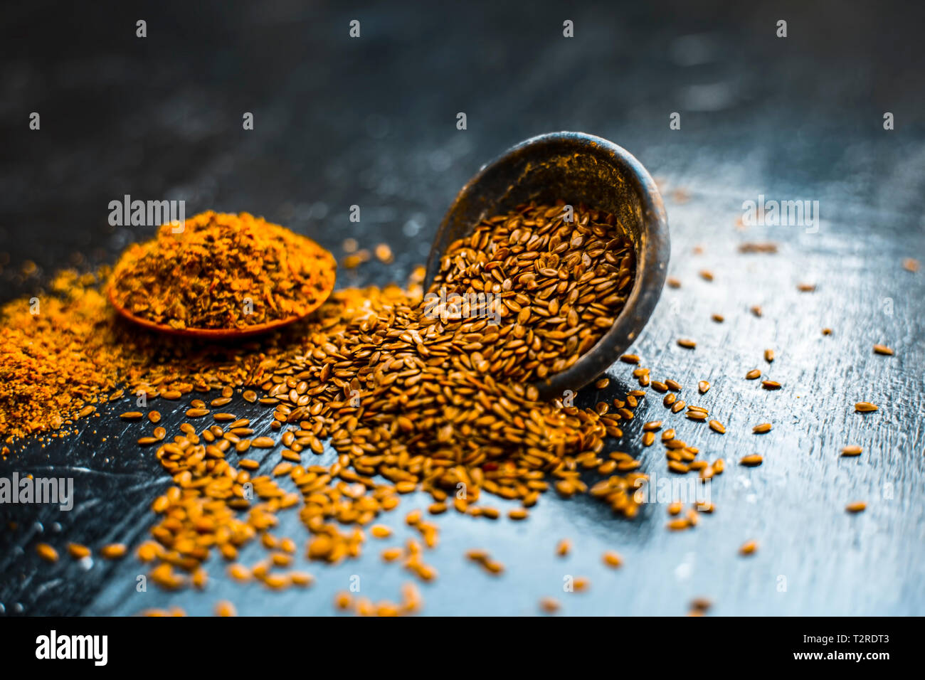 Nahaufnahme von ayurvedische Kraut Alsi oder Adsi oder Leinsamen in einer schwarz gefärbten Ton Schüssel mit dem Pulver auf Holz- Oberfläche in einem Viele ayurvedische Medizin verwendet Stockfoto