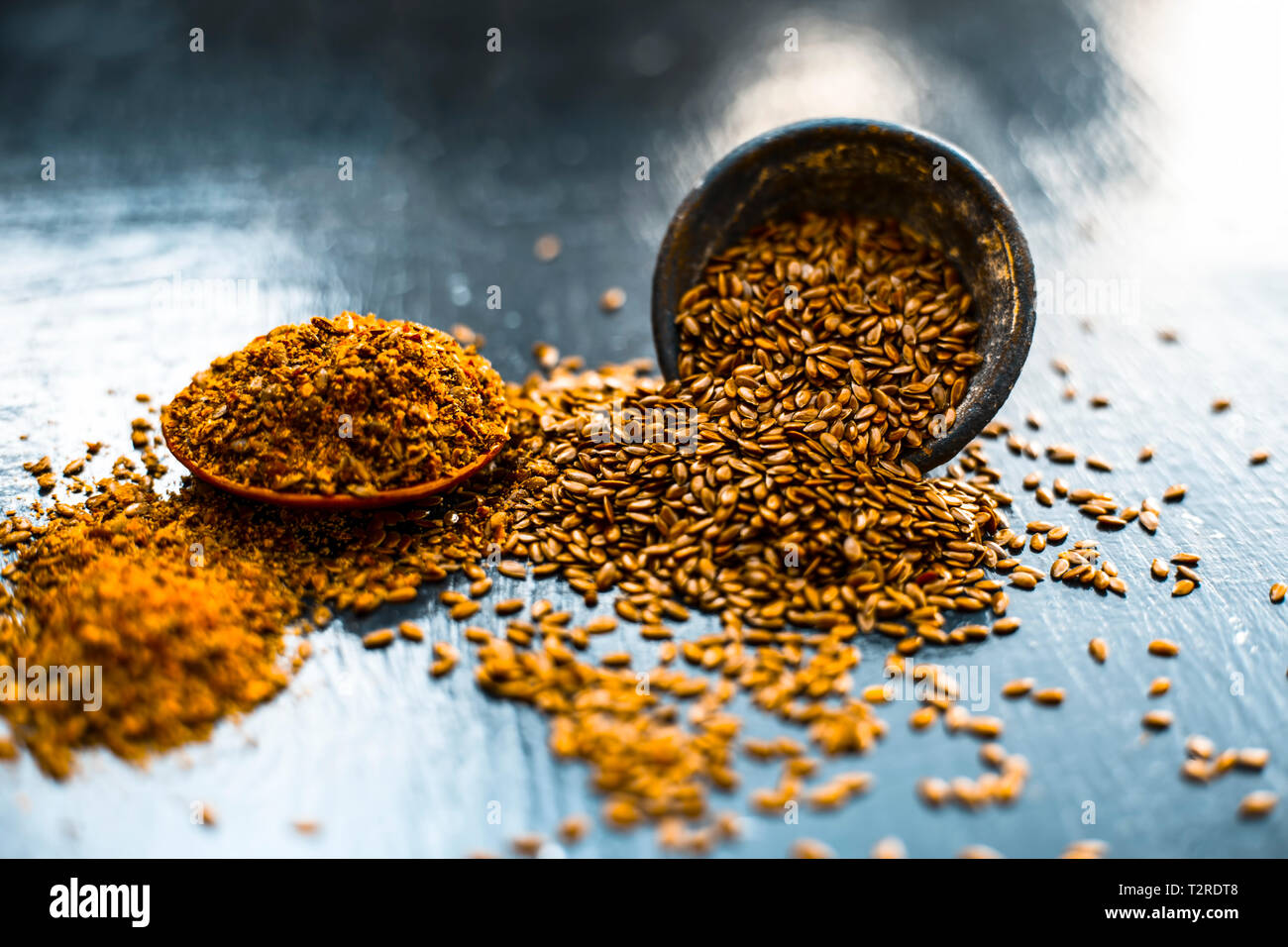 Nahaufnahme von ayurvedische Kraut Alsi oder Adsi oder Leinsamen in einer schwarz gefärbten Ton Schüssel mit dem Pulver auf Holz- Oberfläche in einem Viele ayurvedische Medizin verwendet Stockfoto