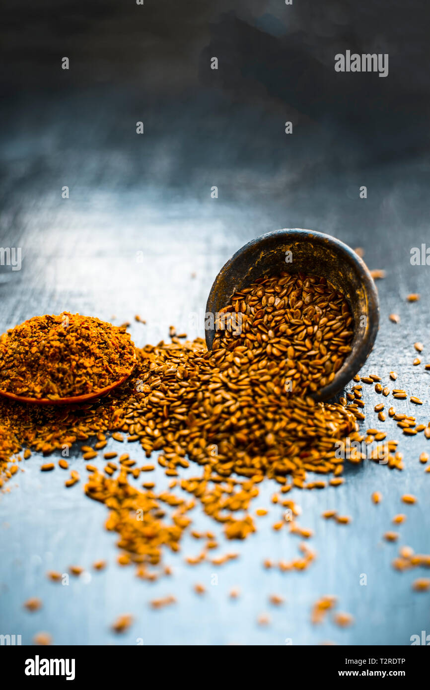 Nahaufnahme von ayurvedische Kraut Alsi oder Adsi oder Leinsamen in einer schwarz gefärbten Ton Schüssel mit dem Pulver auf Holz- Oberfläche in einem Viele ayurvedische Medizin verwendet Stockfoto