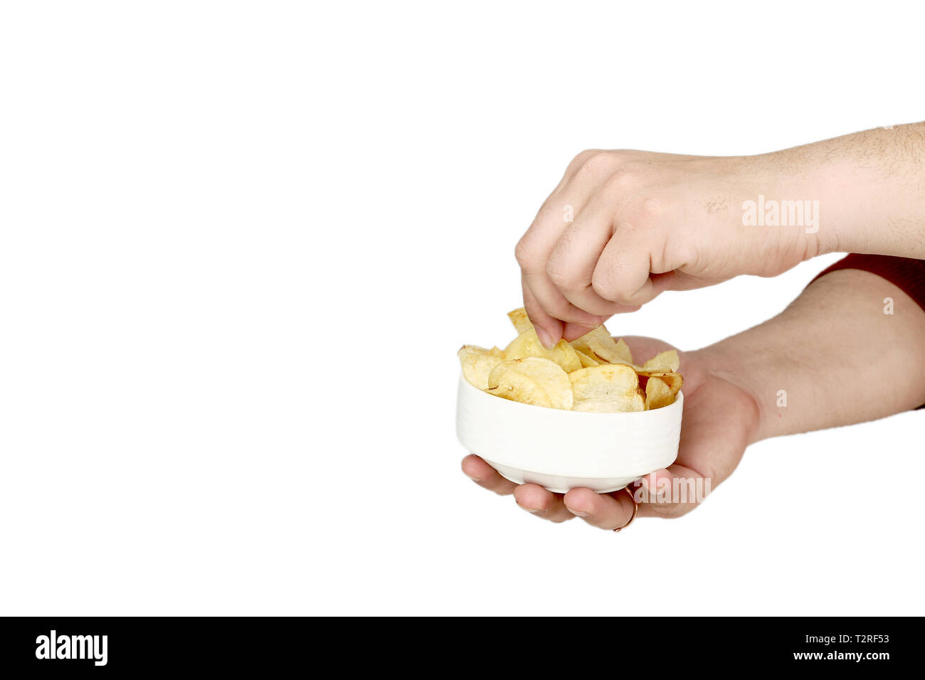 Bild der Mann hält in der einen Hand die Kartoffelchips in der Schüssel und andererseits ist die Kommissionierung Chips. Auf den weißen Hintergrund isoliert. Stockfoto