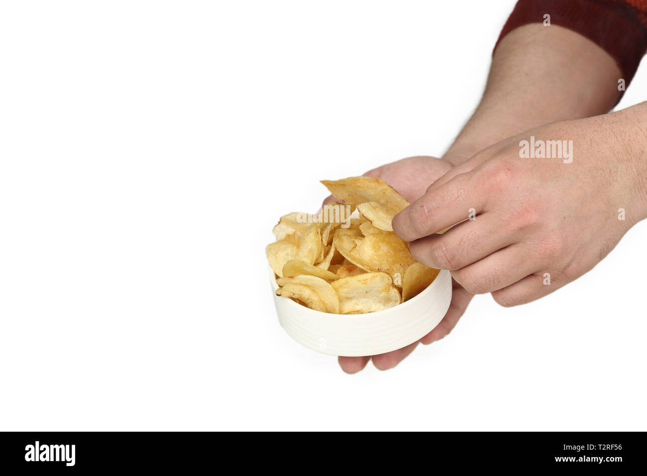 Porträt der Mann hält in der einen Hand die Kartoffelchips in der Schüssel und andererseits ist die Kommissionierung Chips. Auf den weißen Hintergrund isoliert. Stockfoto