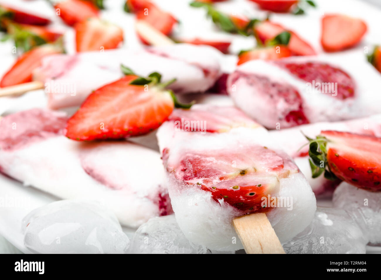 Natürliche saftige Erdbeere Eis am Stiel mit Joghurt oder Eis mit Beeren. Stockfoto