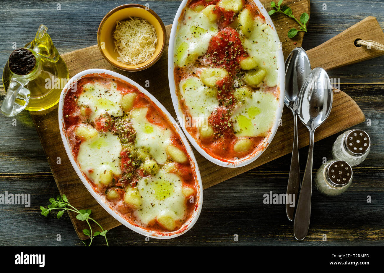Italienischen Klöße gnocchi alla Sorrentina mit Mozzarella Käse, im Ofen gebacken mit Tomatensauce und Kräutern. Mit Parmesan und Würze serviert. Stockfoto