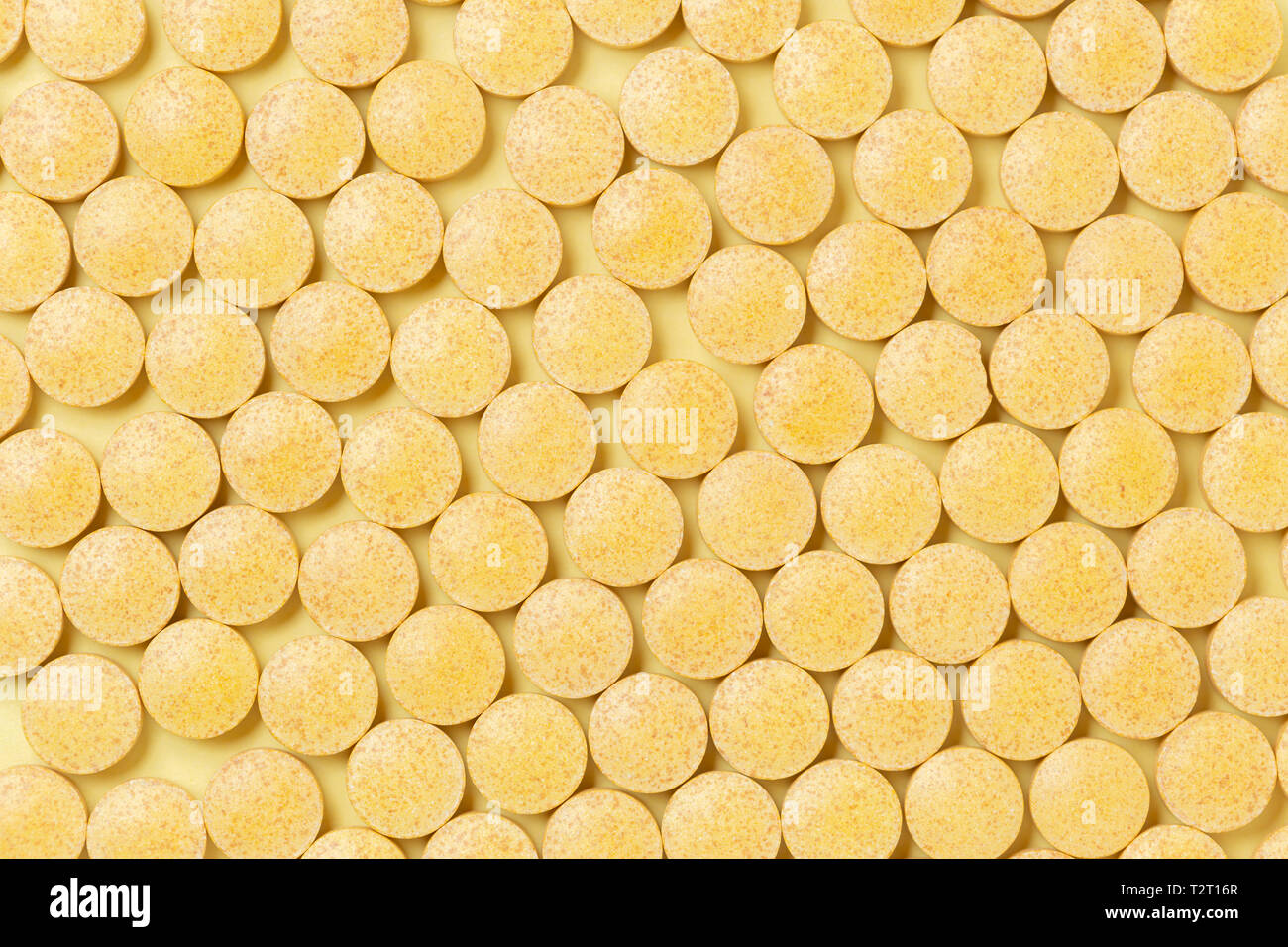 Gelbe pflanzliche Pillen über gelben Hintergrund, Ansicht von oben. Medikamente und verschreibungspflichtige Pillen Hintergrund Stockfoto