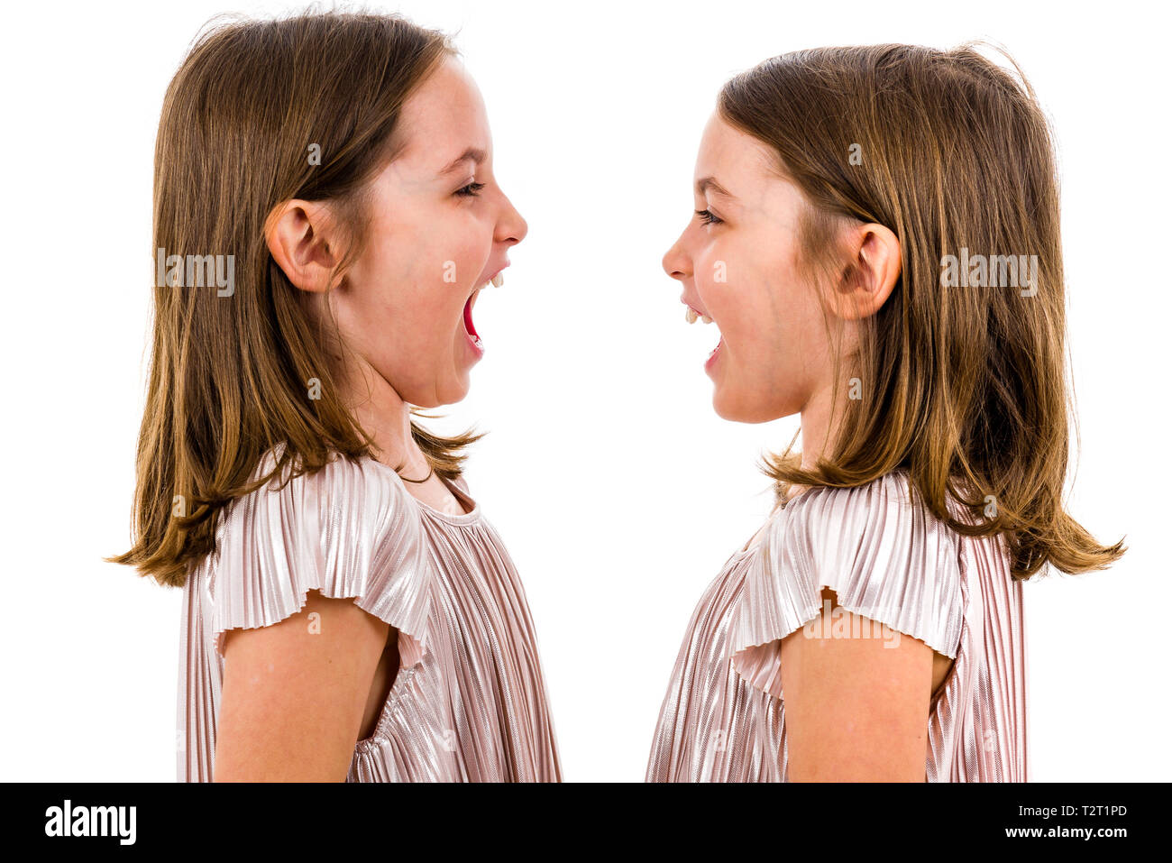 Zwilling Mädchen sind sich einander und lächelnd. Konzept der Familie und schwesterliche Liebe. Profil Seitenansicht des Twin sisters in den Kleidern suchen Stockfoto