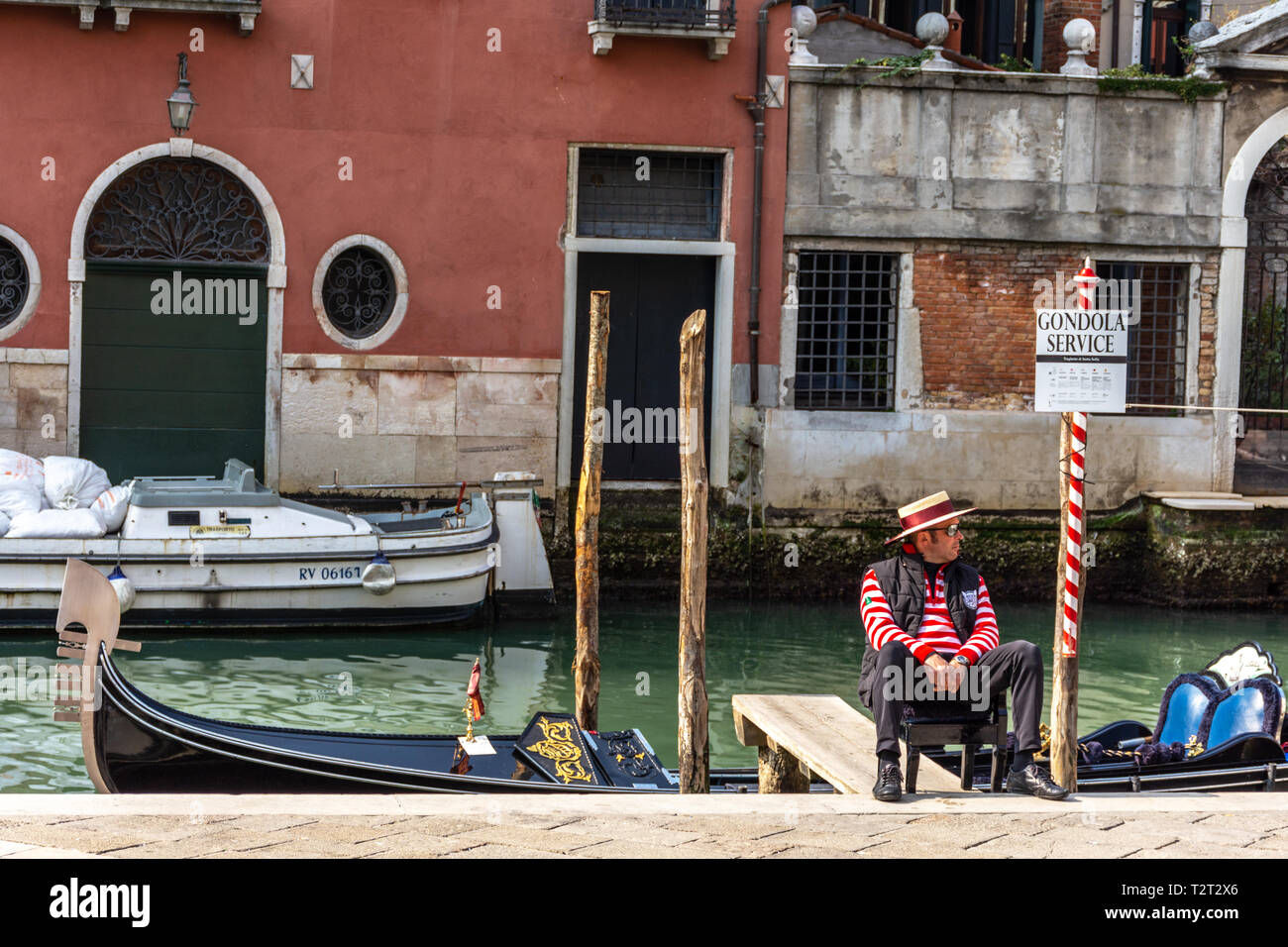 Gondoliere gekleidet in traditionelle rot gestreiften Oberteil und Strohhut mit roter Schleife in Venedig, Italien Stockfoto