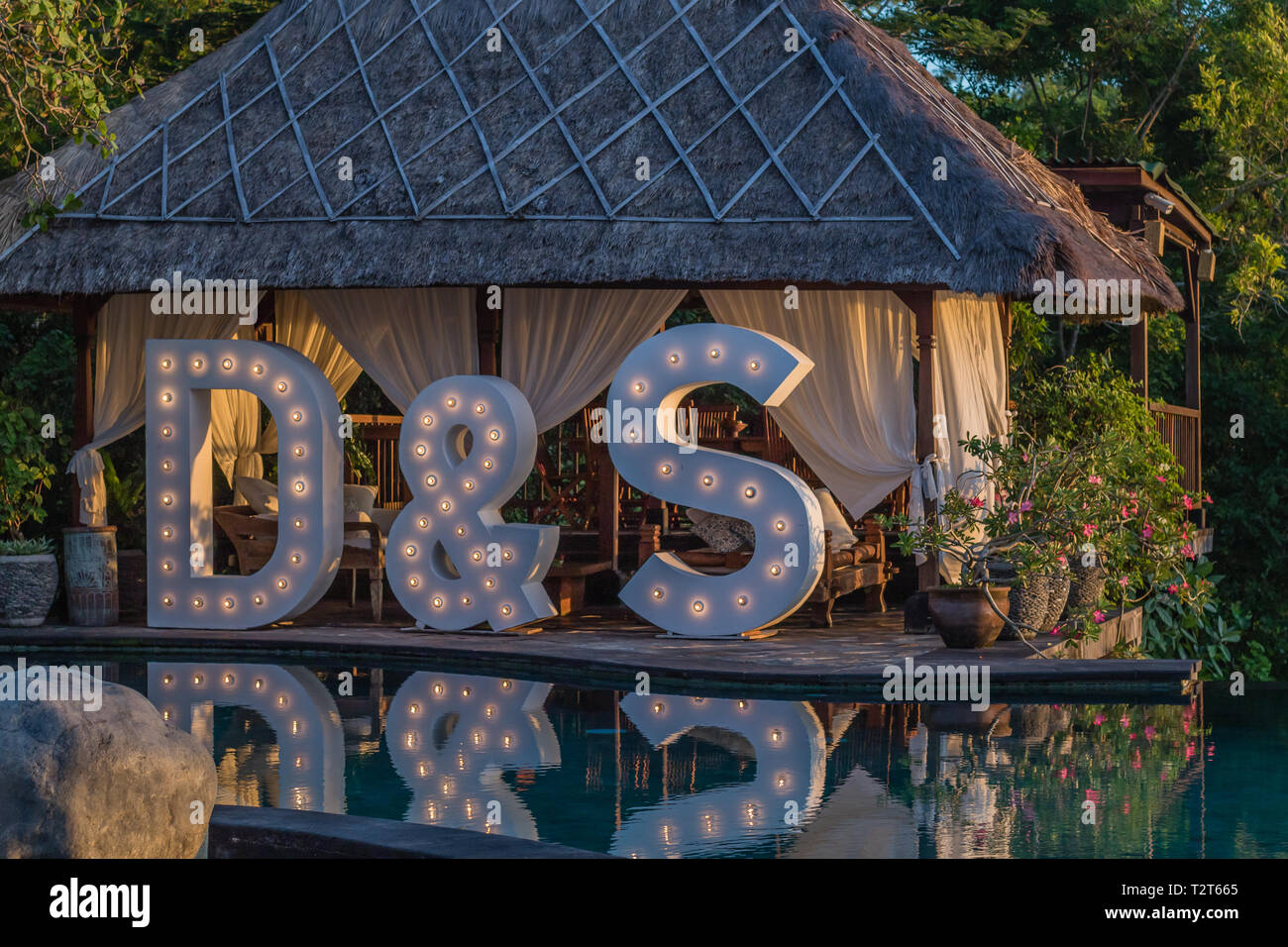 Grosse Hochzeit leuchten Buchstaben D&S in der Nähe der Pool mit Reflexion auf dem Wasser. Feier, Hochzeit, Party. Stockfoto