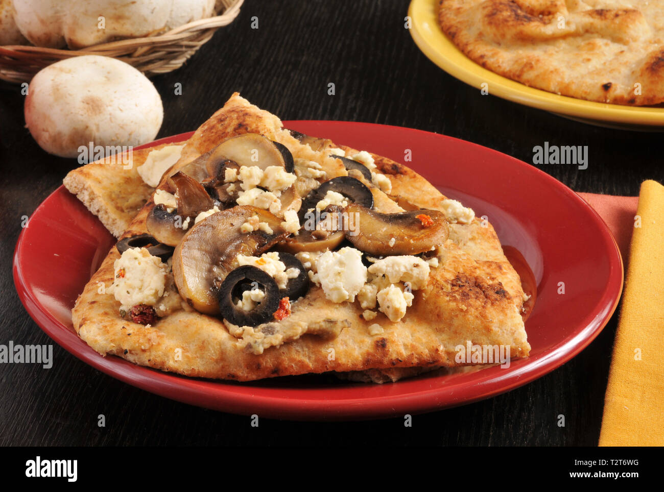 Naan Brot belegt mit schwarzen Oliven, sautierten Pilzen und Feta Käse Stockfoto