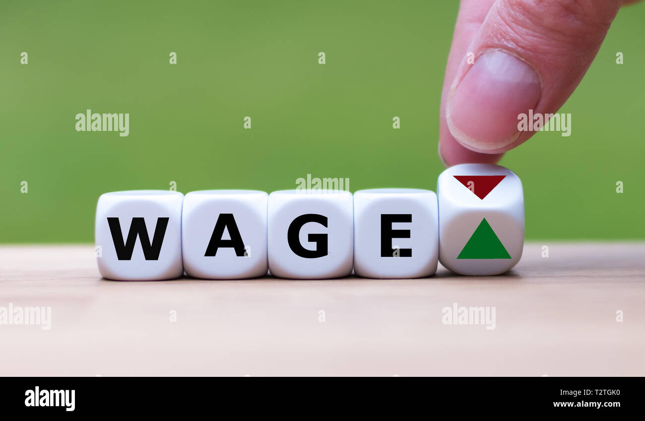 Symbol für eine Gehaltserhöhung. Hand verwandelt einen Würfel und verändert die Richtung, in die sich ein Pfeil von unten nach oben. Würfel Form das Wort 'Lohn'. Stockfoto
