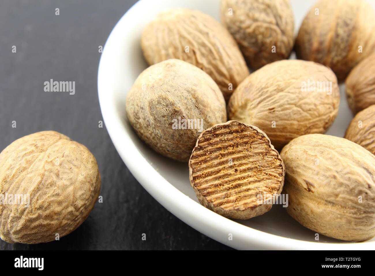 Zusammensetzung der Muskatnuss Samen in einer kleinen Schüssel weiß Stockfoto